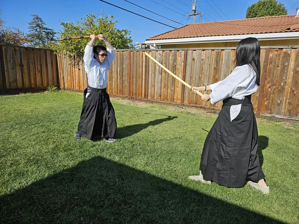 Two students practicing overhead suburi swings